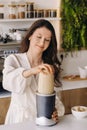 a girl makes a cocktail in a fruit blender in the kitchen. Diet for weight loss