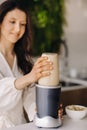 a girl makes a cocktail in a fruit blender in the kitchen. Diet for weight loss