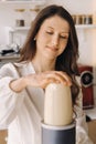 a girl makes a cocktail in a fruit blender in the kitchen. Diet for weight loss