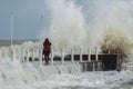 Girl makes extreme selfie on the pier against the background of waves with a risk to life Royalty Free Stock Photo