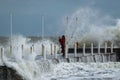 Girl makes extreme selfie on the pier against the background of waves with a risk to life Royalty Free Stock Photo