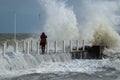 Girl makes extreme selfie on the pier against the background of waves with a risk to life Royalty Free Stock Photo