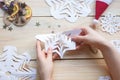 the girl makes a homemade snowflakes cut out of paper, preparation for the new year, Christmas Royalty Free Stock Photo