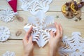 the girl makes a homemade snowflakes cut out of paper, preparation for the new year, Christmas Royalty Free Stock Photo