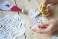 The girl makes a homemade snowflakes cut out of paper, preparation for the new year, Christmas Royalty Free Stock Photo