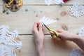 The girl makes a homemade snowflakes cut out of paper, preparation for the new year, Christmas Royalty Free Stock Photo