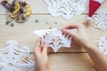 The girl makes a homemade snowflakes cut out of paper, preparation for the new year, Christmas Royalty Free Stock Photo