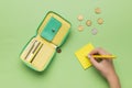 The girl makes notes on paper next to her purse and scattered coins. The concept of budget management Royalty Free Stock Photo