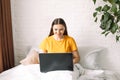 Girl makes online purchases through laptop while sitting in bed Royalty Free Stock Photo