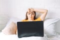Girl makes online purchases through laptop while sitting in bed Royalty Free Stock Photo
