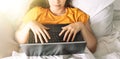 Girl makes online purchases through laptop while sitting in bed Royalty Free Stock Photo