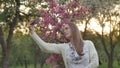 Girl makes selfie in the garden. An attractive red-haired woman smiles making selfi using a mobile phone in a cherry Royalty Free Stock Photo