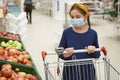 Girl makes stock of products. Reaching food shelf