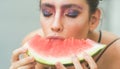 Girl with makeup face and red melon