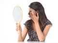 Girl with makeup mirror adjusting her makeup