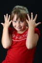 Girl making elephant ears with her hands on black