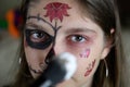 A girl making a Halloween makeup for day of the dead or Halloween at home