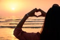 Girl making heart shape with hands in the sunset Royalty Free Stock Photo