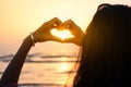 Girl making heart shape with hands in the sunset Royalty Free Stock Photo
