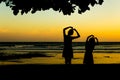 Girl making heart shape at sunset beach. Royalty Free Stock Photo