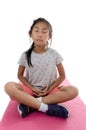 Girl making meditaion on pink yoga mat with white background..