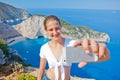 Girl making photo with Navagio bay and Ship Wreck beach in summer. The famous natural landmark of Zakynthos, Greek