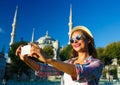 Girl making selfie by the smartphone on the background of the Bl