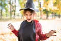 Girl making sinister face with paper black hat