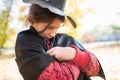 Girl making sinister face with paper black hat