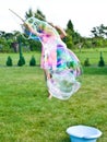 Girl making soap bubbles in home garden Royalty Free Stock Photo
