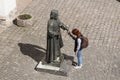 Girl making a wish to statue of prince Podolsky Fedir Koryatovych 1331-1414 in castle Palanok, Mukachevo, Ukraine photo: MUKACHE Royalty Free Stock Photo