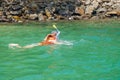 The girl in a mask dives under water to watch the underwater world