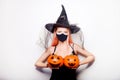 The girl in the mask holds a pumpkin. Halloween party, be sure to wear masks. COVID-19