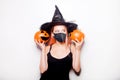 The girl in the mask holds a pumpkin. Halloween party, be sure to wear masks. COVID-19