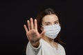 A girl in a mask shows a stop gesture fearing for the health of people Royalty Free Stock Photo