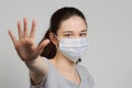 A girl in a mask shows a stop gesture fearing for the health of people