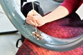 Girl master draws patterns on rim wheel of custom motorcycle Royalty Free Stock Photo