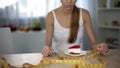 Girl measuring piece of cake with tape, fear of gaining weight, food restriction