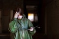 Girl medic in a mask and a protective suit stands in the clinic with documents