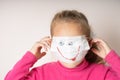 girl in a medical mask with a painted smile