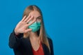 A girl in a medical mask shows her hand stop