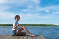 Girl meditates in nature by the lake on a nice sunny day