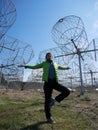 A girl meditating on one leg against a backdrop of large antennas