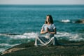 A girl meditating on the sea beach during a wonderful sunrise. Yoga and fitness.