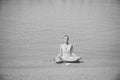 Girl meditating in yoga pose with coffee cup at water Royalty Free Stock Photo