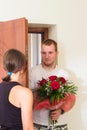 Girl meets boyfriend with flowers near the door