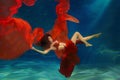 Girl mermaid. Underwater scene. A woman, a fashion model in the water in a beautiful dress swims like a fish Royalty Free Stock Photo