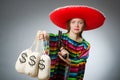 Girl in mexican poncho holding handgun and money Royalty Free Stock Photo