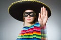 The girl in mexican vivid poncho against gray Royalty Free Stock Photo