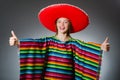 The girl in mexican vivid poncho against gray Royalty Free Stock Photo